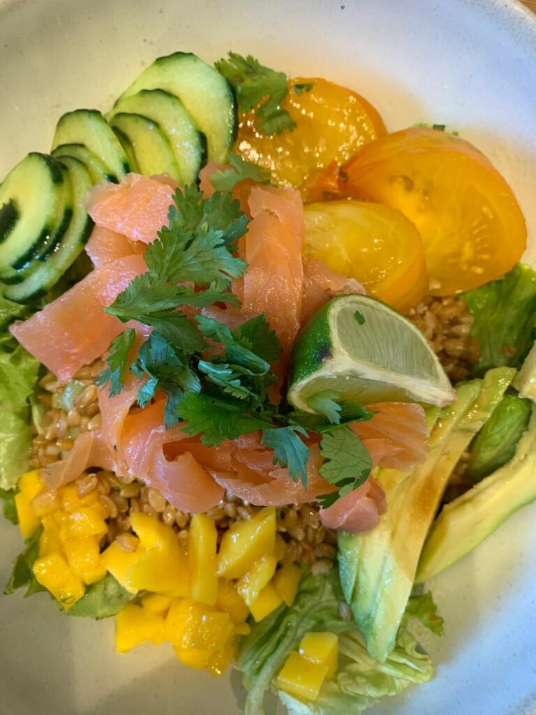 Assiette fraîche et colorée au saumon fumé, avocat, mangue, concombre et tomates jaunes, servie au salon de thé Little Miss Goumard à Cheverny.